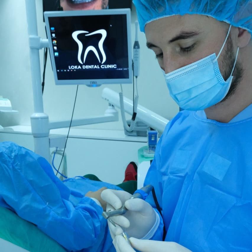 Un dentista lavora con attenzione durante un trattamento